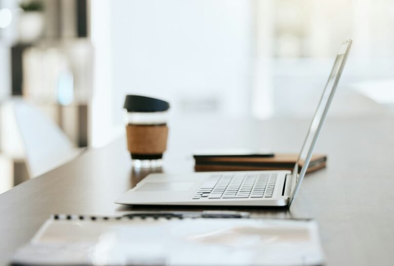 Empty table with files, coffee and laptop with notebook, folder and financial portfolio of economy,